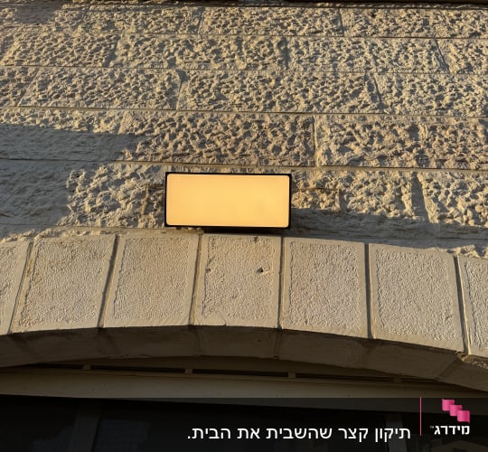 מנורה על קיר אבן חיצוני בשמש